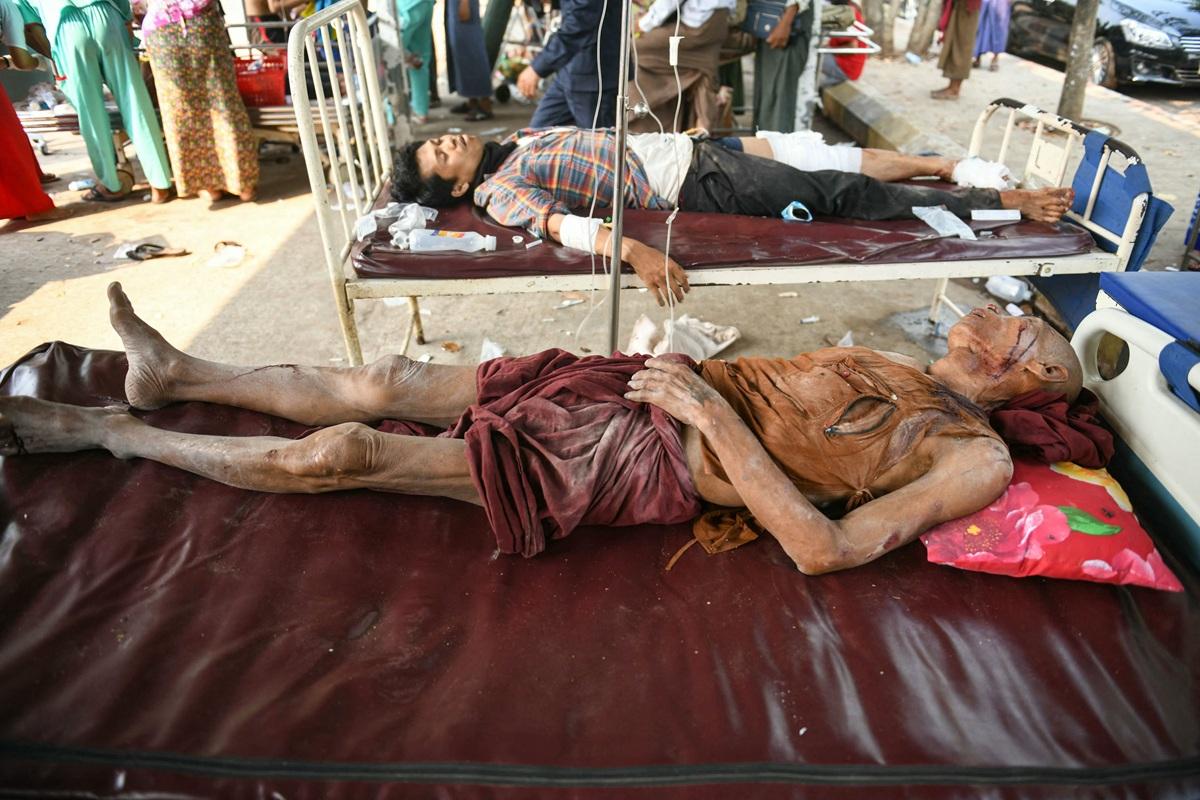 Earthquake survivors lie on a bed in the compound of a hospital in central Myanmar. Photo: AFP