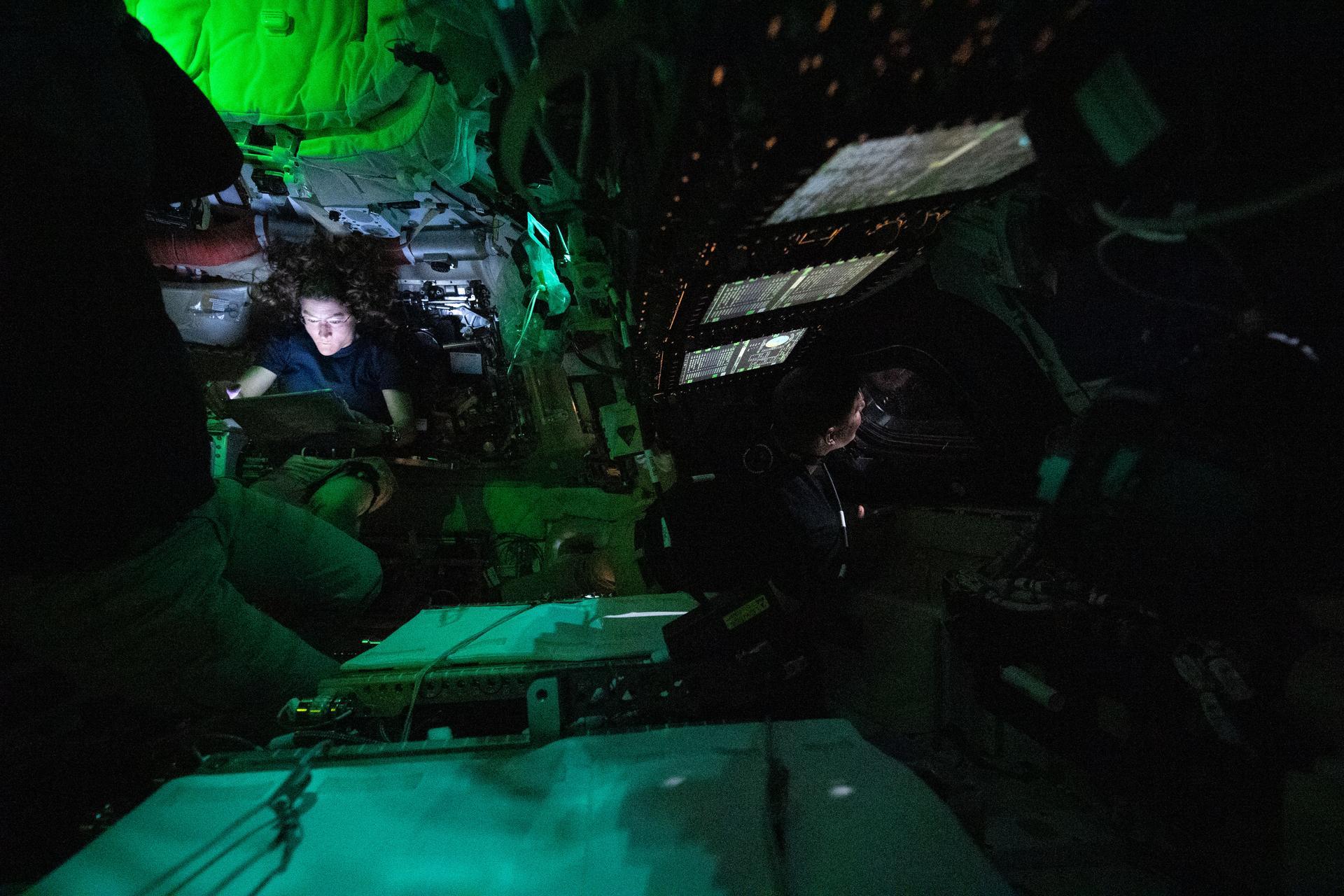 NASA astronaut Christina Koch is illuminated by a screen as CSA (Canadian Space Agency) astronaut Jeremy Hansen looks out a window on the third day of the Artemis II mission. Photo: NASA