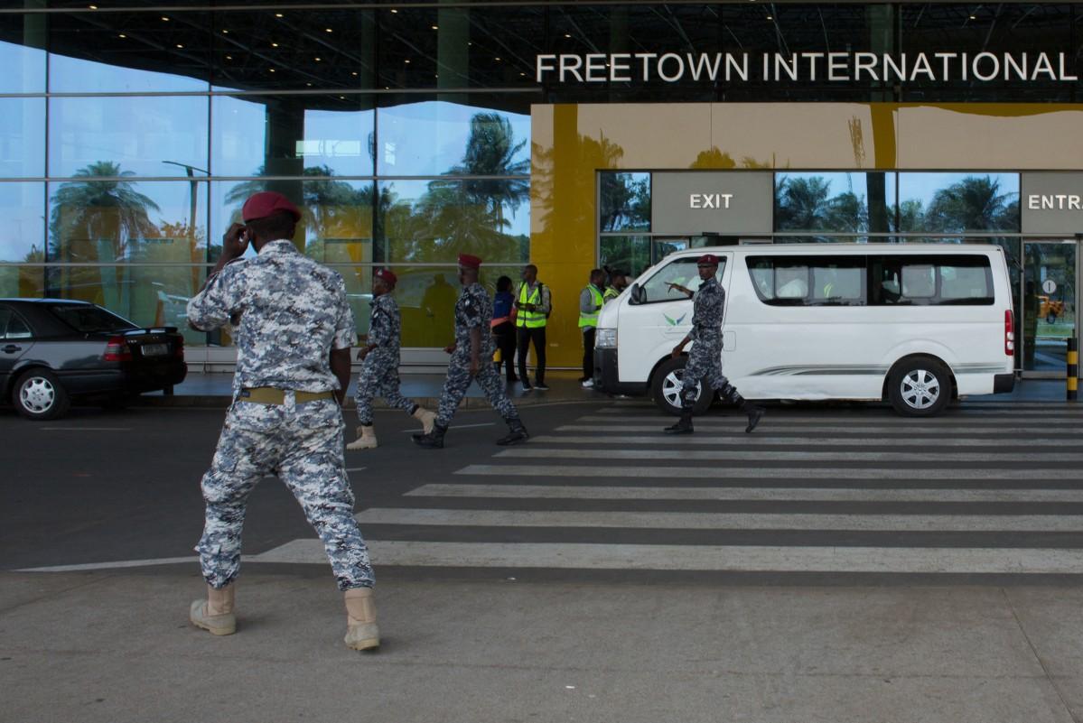 Security escort migrants in a National Public Health Agency (NPHA) after their arrival at Freetown International Airport, formerly known as Lungi International Airport. Photo: AFP