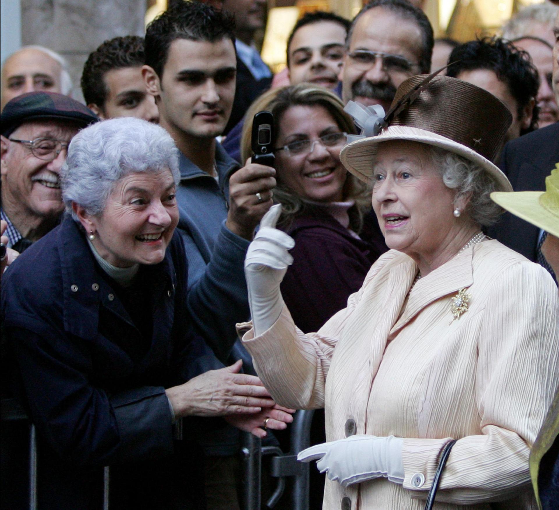 Queen Elizabeth II (R) talks with British tourists as she walks in the streets of Valletta, 23 November 2005. Photo: AFP