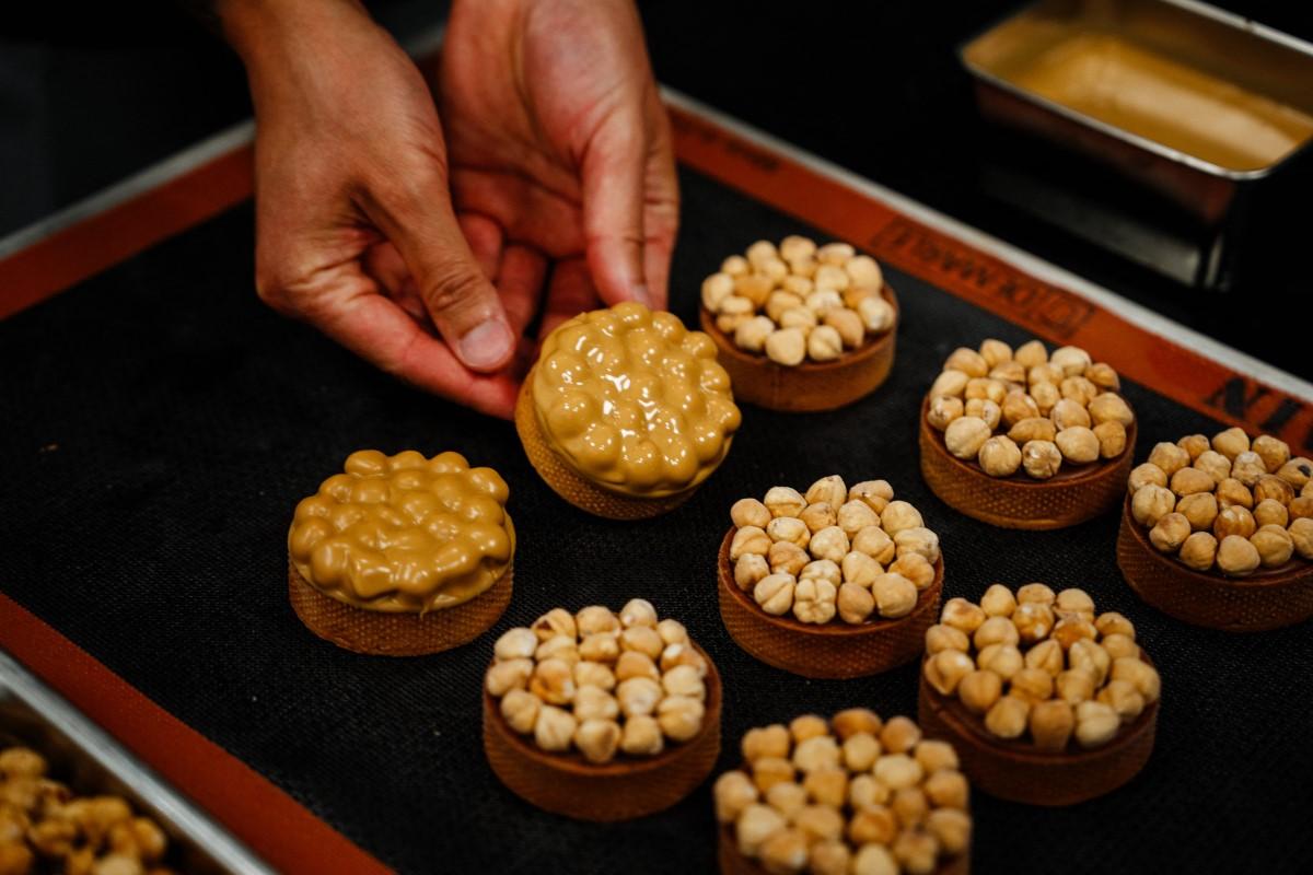Pastry chef from Nice Philippe Tayac displays tartelettes with hazelnuts and 'blond' chocolate at Valrhona chocolatier.