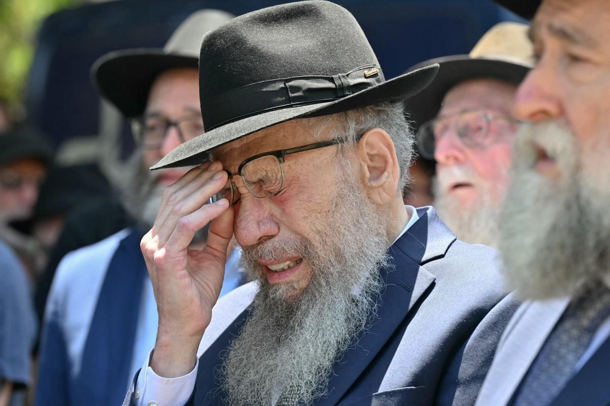 A mourner weeps as he follows the hearse. Photo: AFP