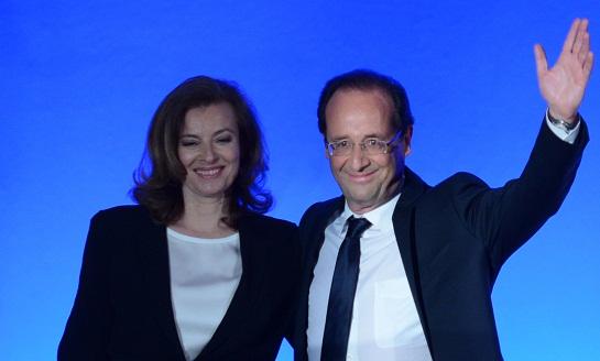 Socialist Party (PS) newly elected president Francois Hollande poses flanked by his companion Valerie Trierweiler this evening.