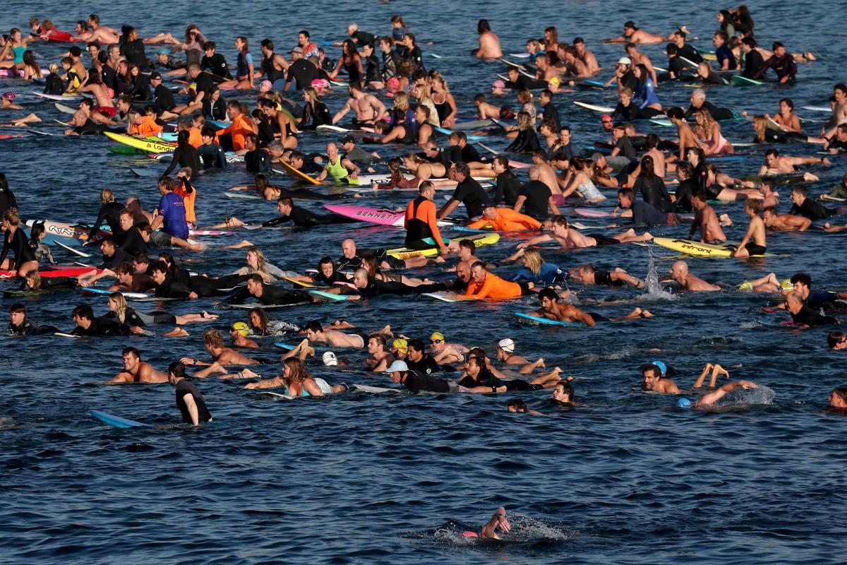 Surfers and swimmers congregate in the surf at Bondi Beach on Saturday as a tribute. Photo: AFP