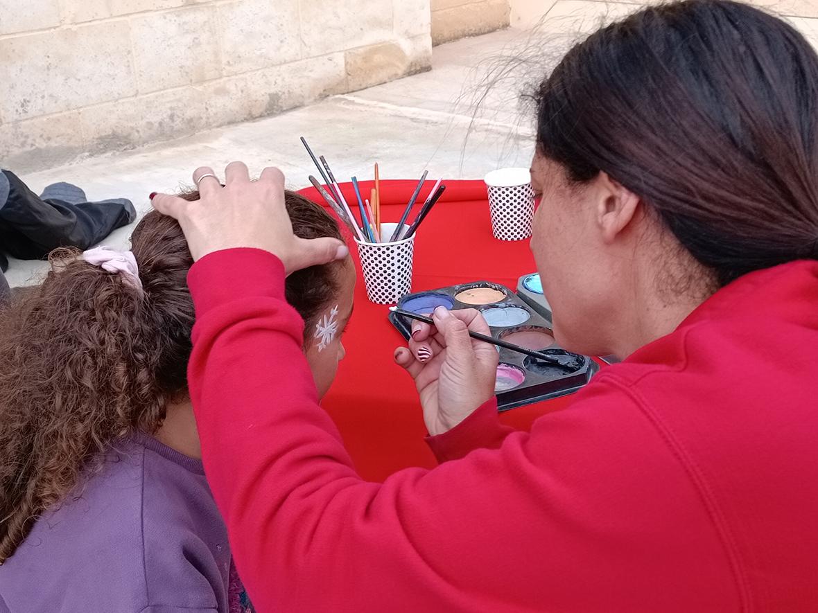 A child having her face painted.