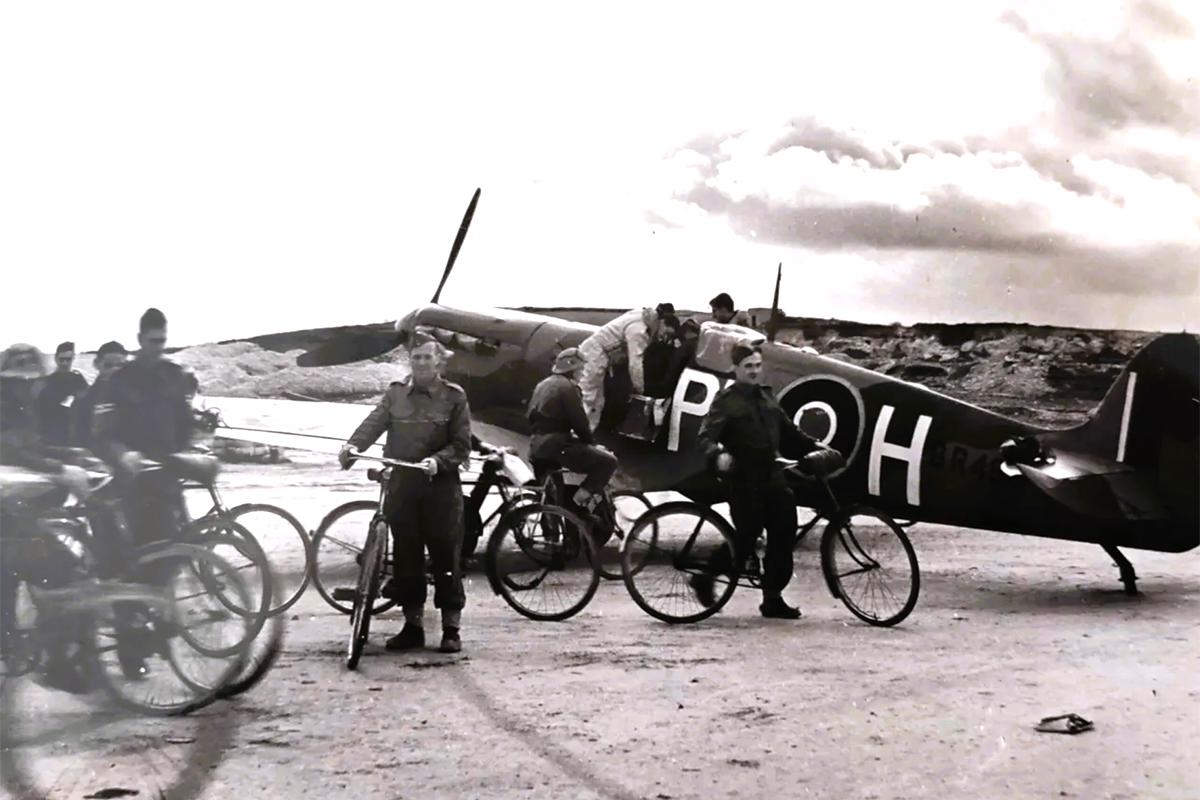 Servicemen with bicycles circling a plane in WWII.
