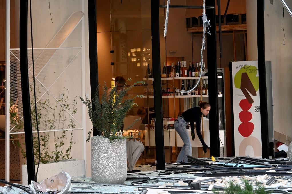 An employee cleans the debris in front of a cafe in the damaged areas of Ukranian capital following a large-scale Russian drone and missile attacks in Kyiv. Photo: AFP