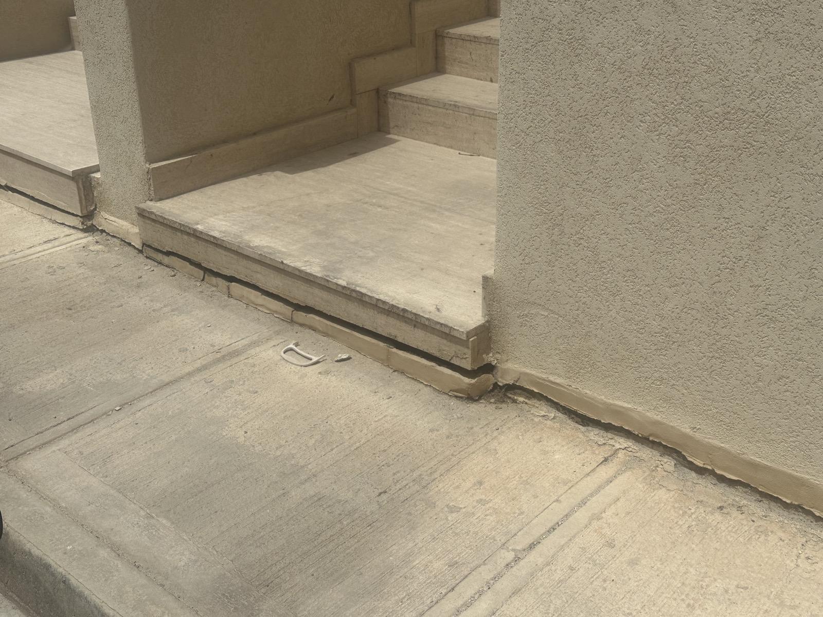 The crack above the pavement affected the facade of the apartment block.