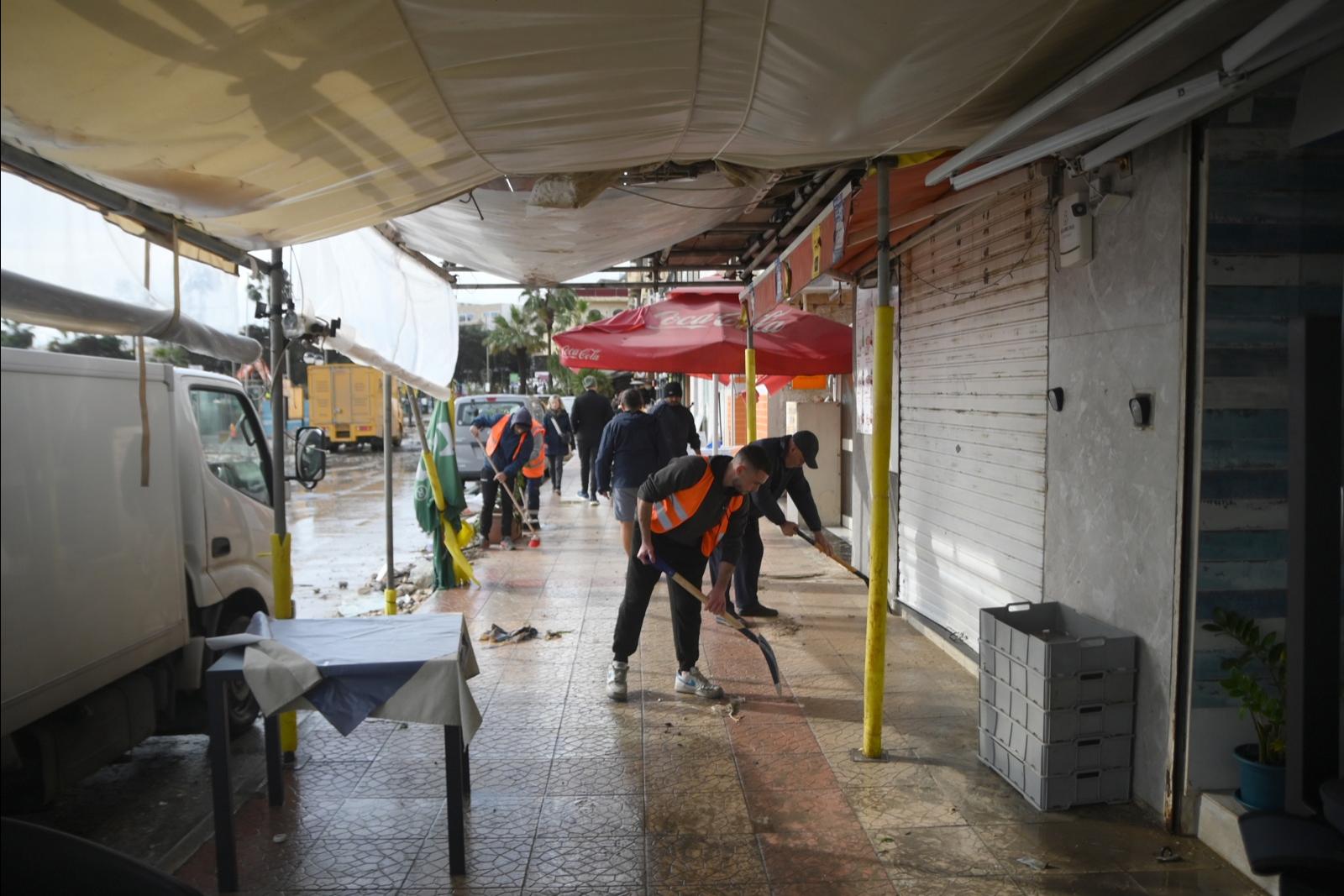 Volunteers joined shop workers and government personnel in the cleanup. (Jonathan Borg)