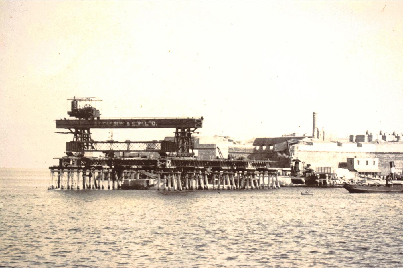 Heavy machinery for constructing an arm of the Grand Harbour breakwater, early 1900s.