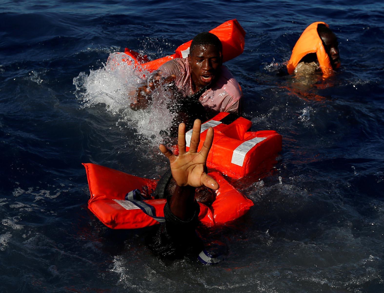 Migrants struggling at sea during a rescue operation.