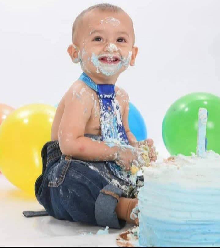 Zaylen smiles while digging into a cake.