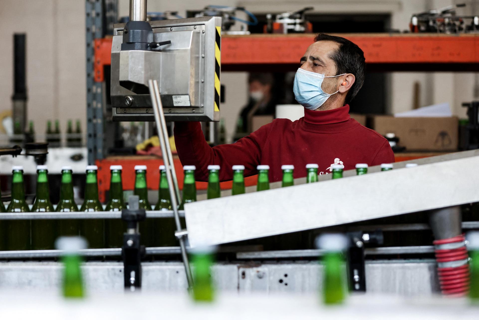 A technician checks bottles on a production line in the Silly brewery.
