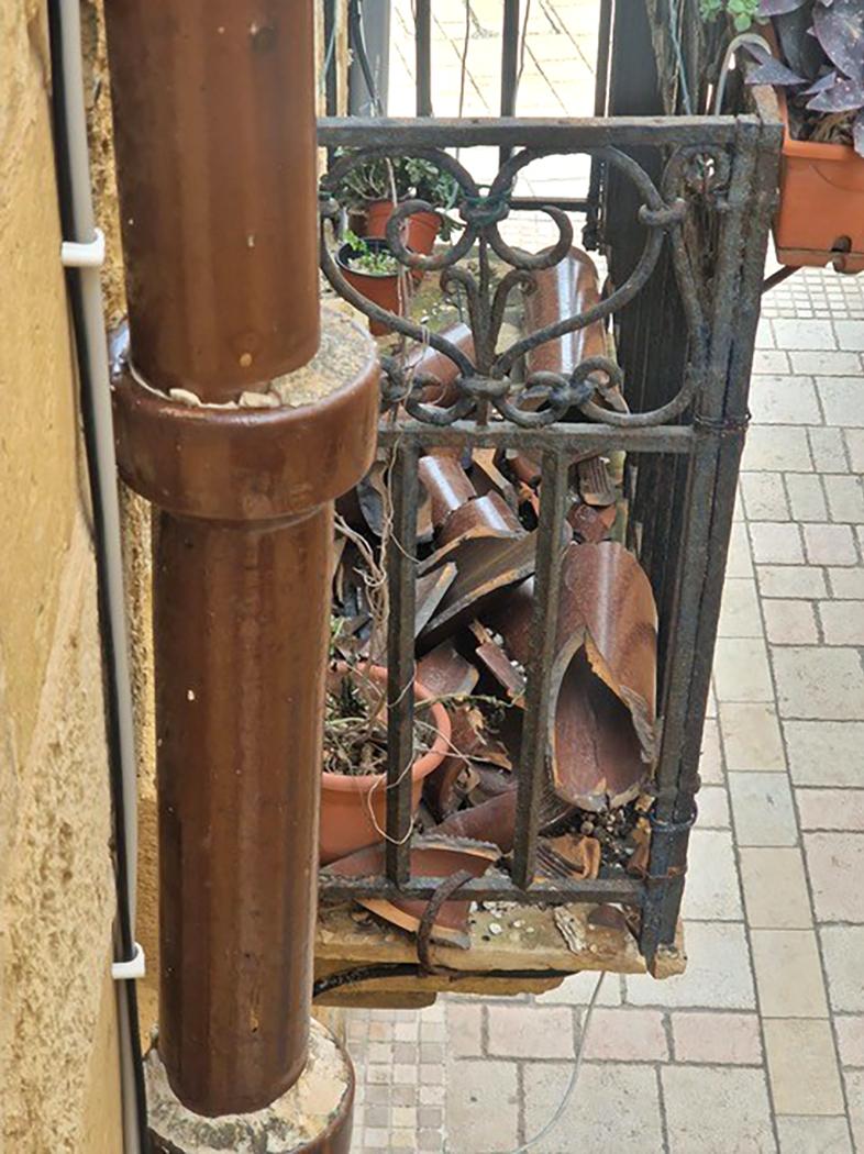 Broken pipes and sharp shards sitting on a balcony in Vittoriosa.