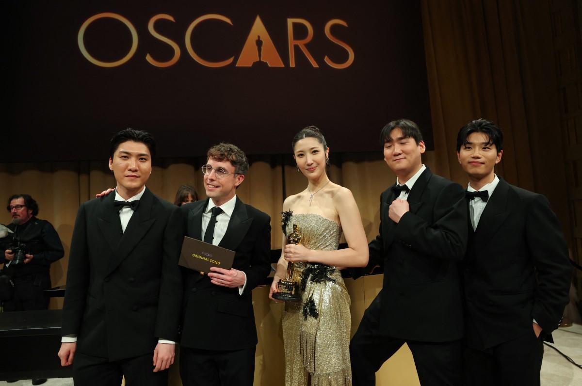 South Korean-US singer Ejae holds the Oscar for Best Music (Original Song) for Golden from KPop Demon Hunters with Jeong Hoon Seo (L), US songwriter Mark Sonnenblick (2L), Hee Dong Nam (2R) and Yu Han Lee (L). Photo: AFP