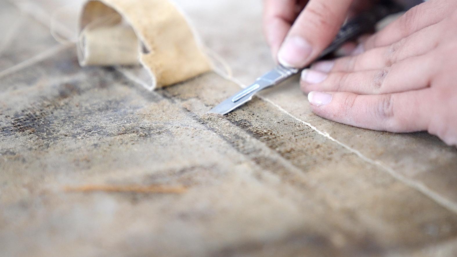 Removal of the lining canvas and adhesive.
