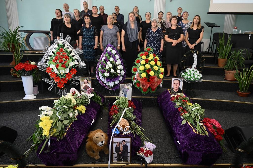 Attendees sing in a chorus during a funeral ceremony for Mykyta and Sofia Lamekhov and their son Levi. Photo: AFP