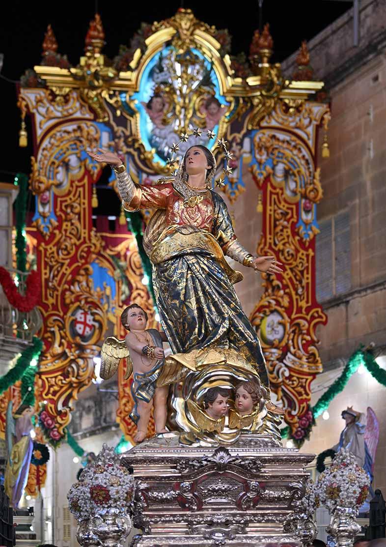 The titular statue of Mqabba parish church in front of the archway during the feast of the Assumption of Our Lady.