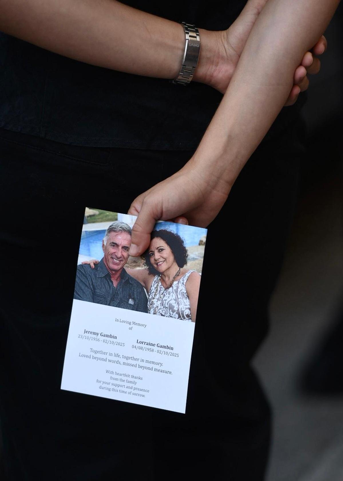 Mourner holding the couple's prayer card Photo: Chris Sant Fournier