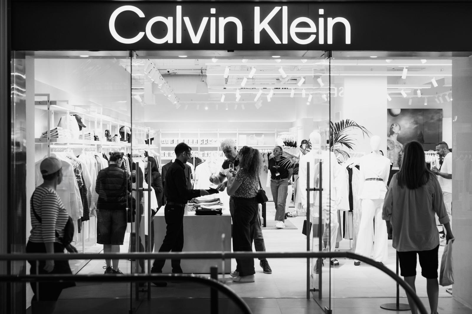 Visitors exploring the newly reopened Calvin Klein store while enjoying refreshments.