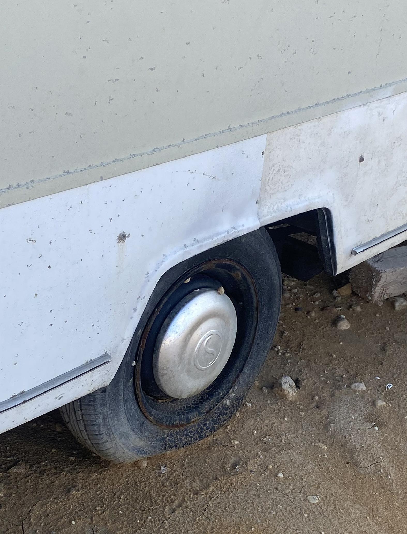 Some caravans have deflated tyres, indicating they have been set up camp a while ago.