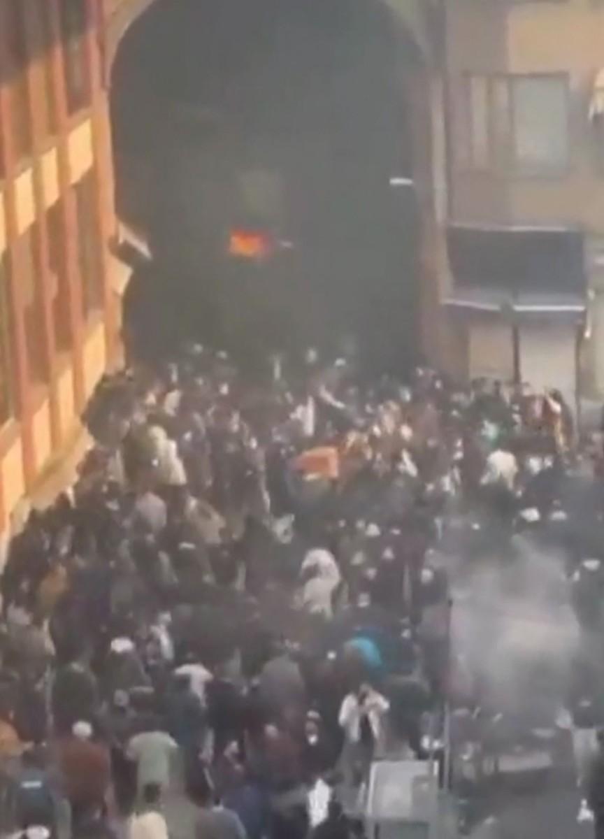 A social media grab shows protesters clashing with Iranian security forces at the Tehran bazaar.