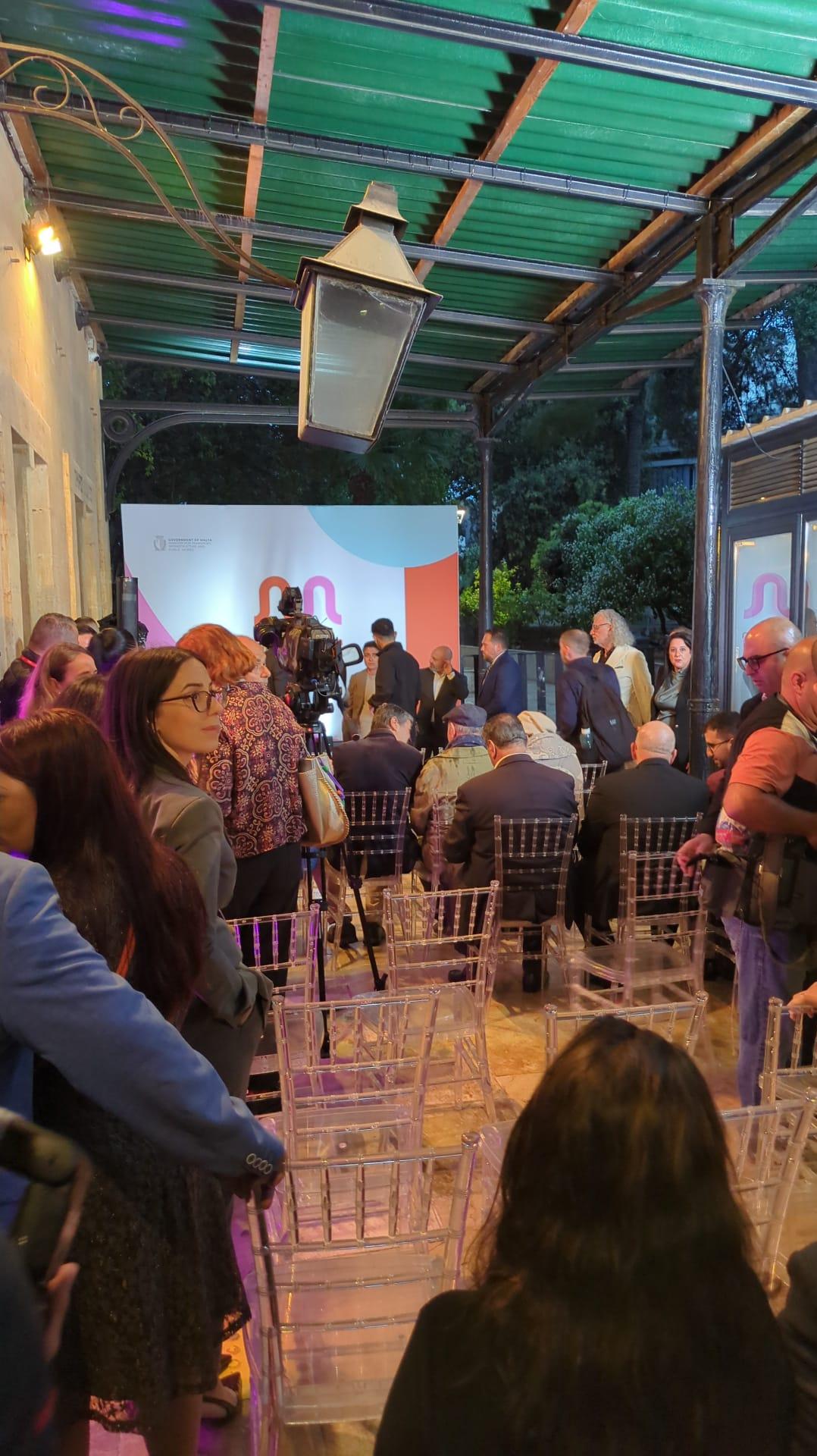 Staff carried chairs underneath a canopy so that the presentation could continue after the rain. Photo: Neville Borg