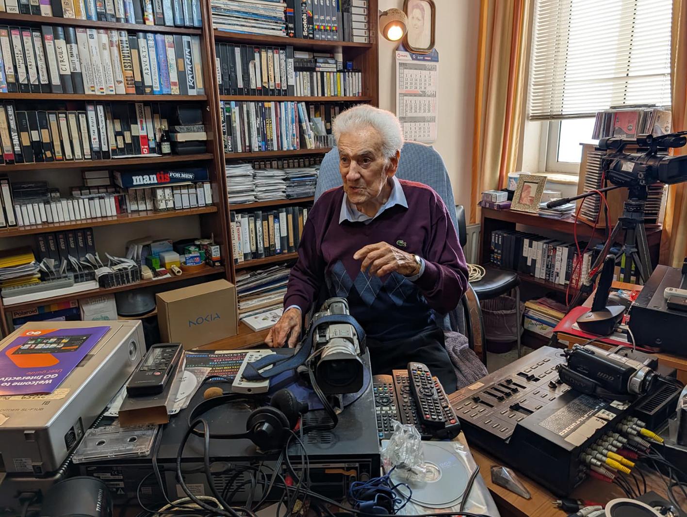 Cecil Bartoli surrounded by cameras, projectors and VHS tapes, alongside awards from the Malta Amateur Cine Circle. Photo: Chris Sant Fournier