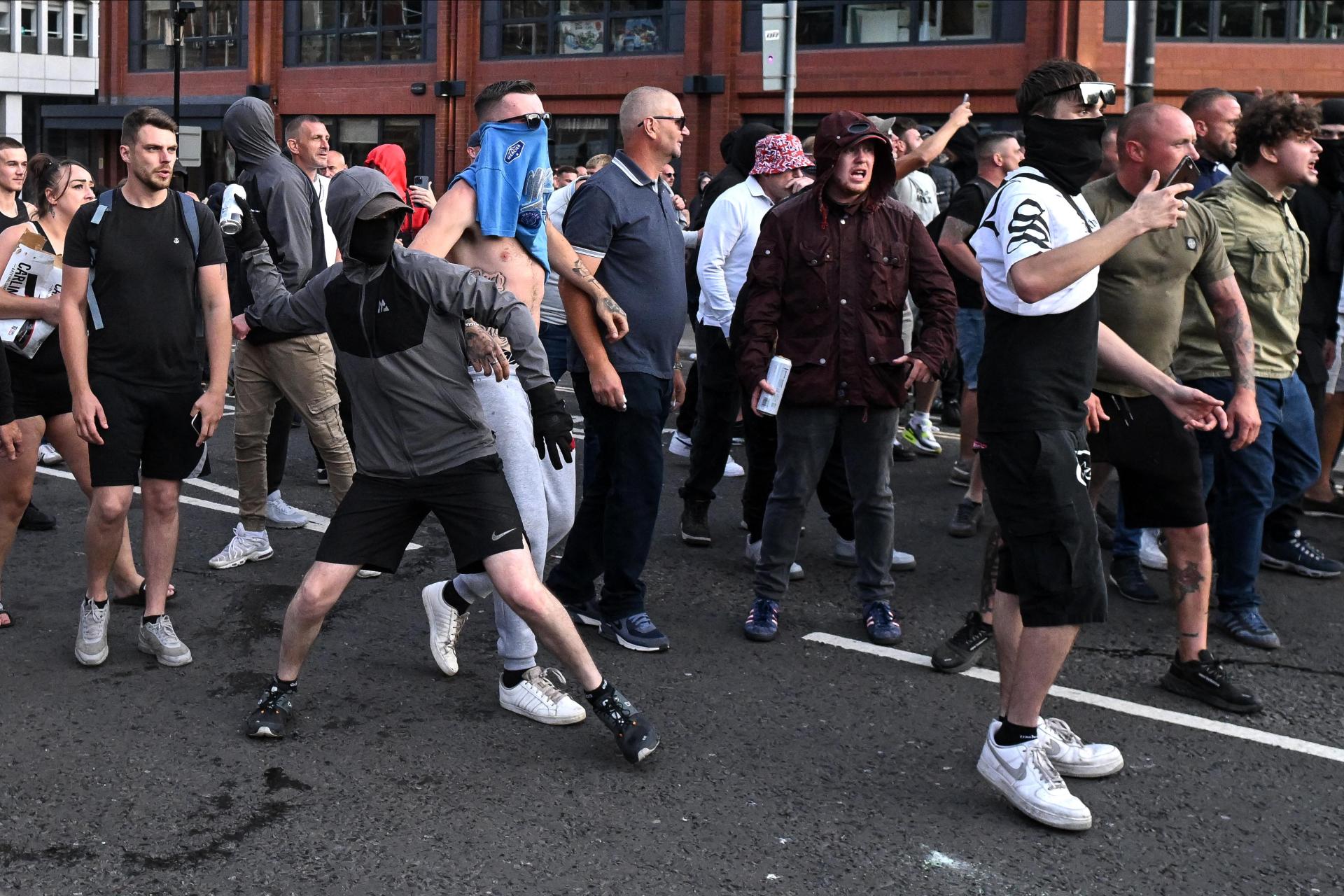 A masked protester throws a can of beer towards riot police. Photo: AFP