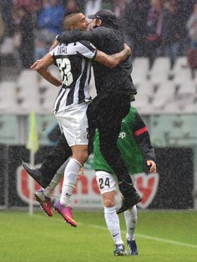 Singing in the rain... Juventus midfielder Arturo Vidal (left) embraces coach Antonio Conte after scoring yesterday.