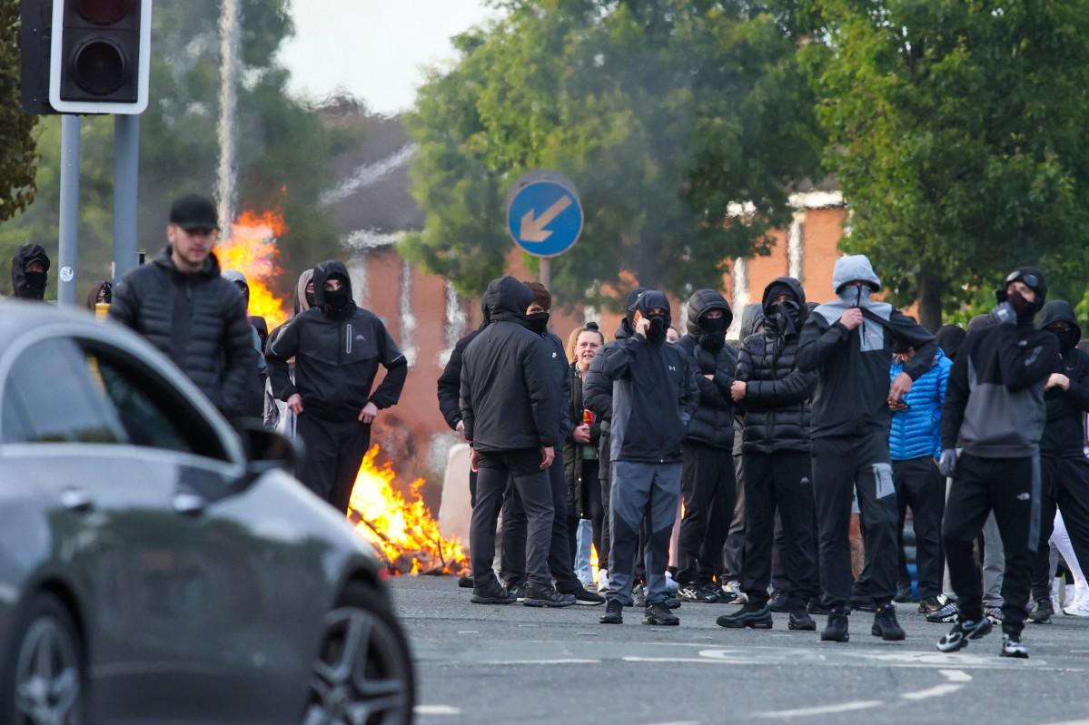 Masked youths block a road with burning debris in north Belfast, Northern Ireland. Photo: AFP