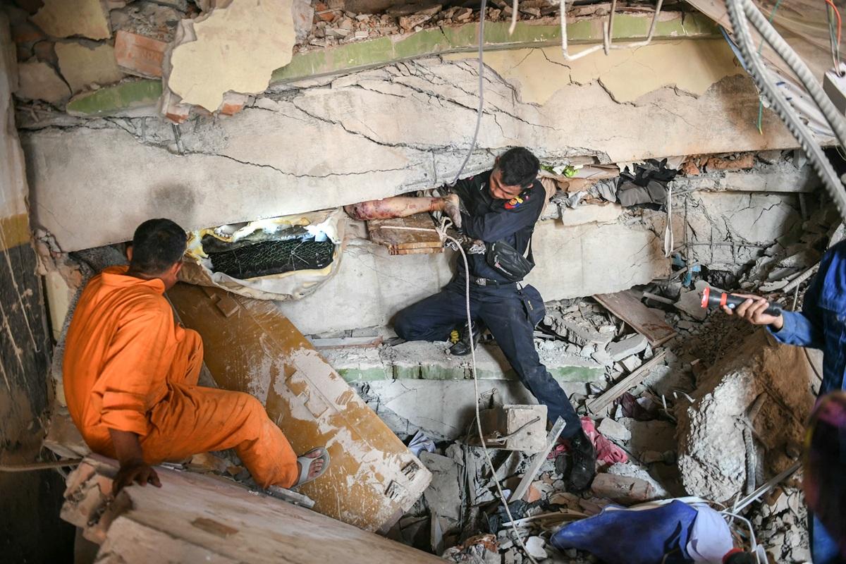 Rescue workers attempt to free a resident trapped under the rubble of the destroyed Sky Villa Condominium in Mandalay. Photo: AFP