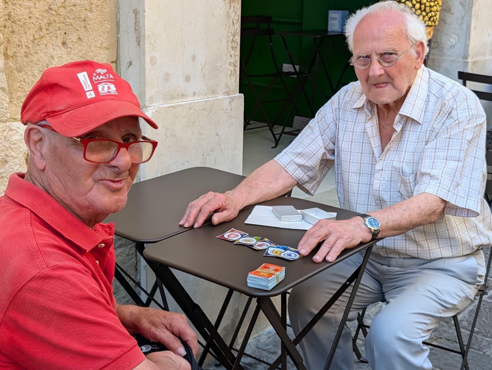 Nestu Barbara and Francis Spina exchanging stickers in Valletta outside Anastasi.