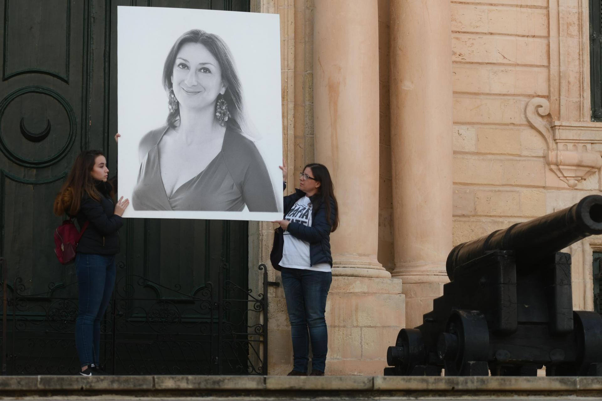 Activists hold up a poster of Daphne Caruana Galizia outside the Office of the Prime Minister in December 2019. Photo: Jonathan Borg