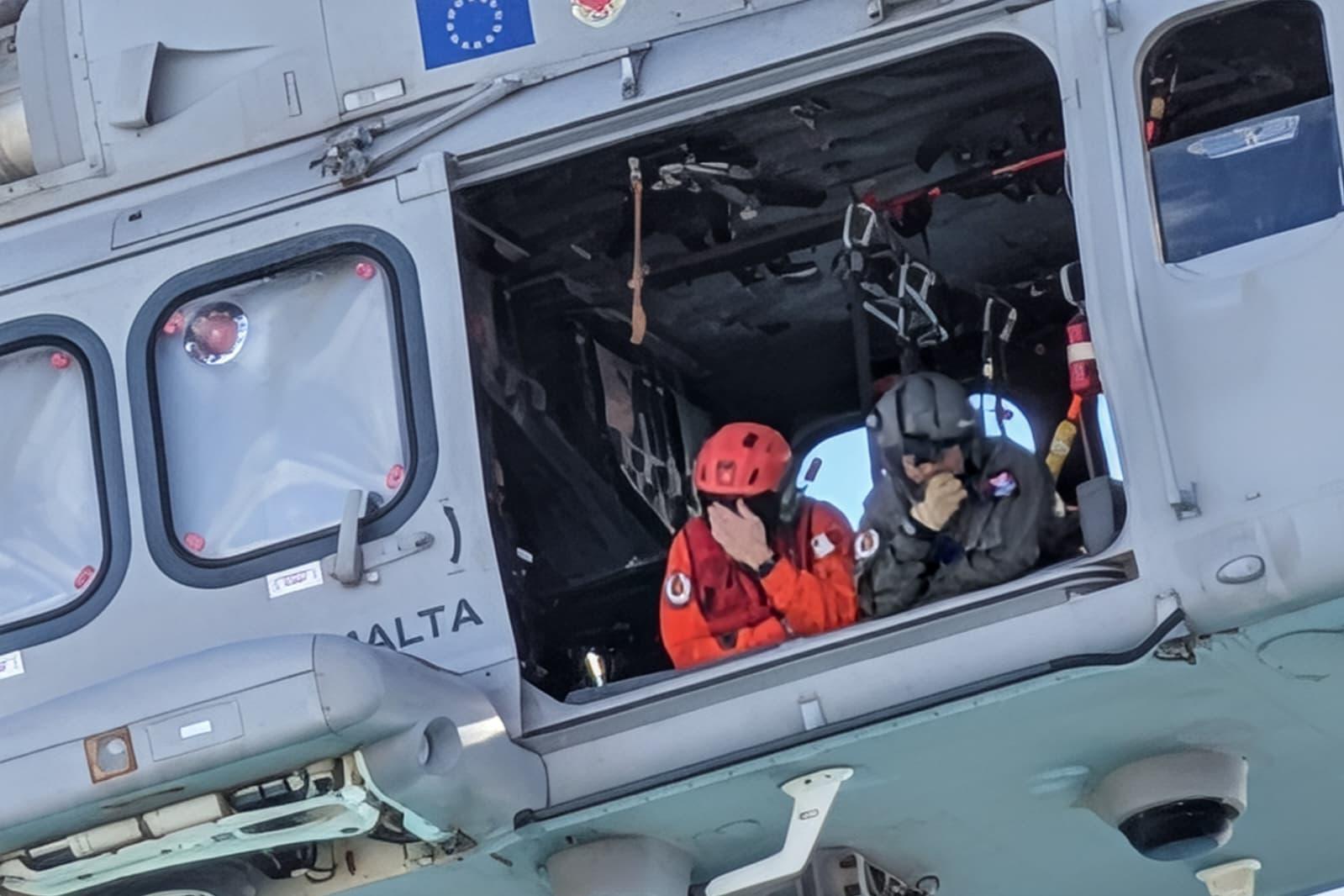 Rescuers lean out of an AFM helicopter looking for the missing girl. Photo Chris Sant Fournier.