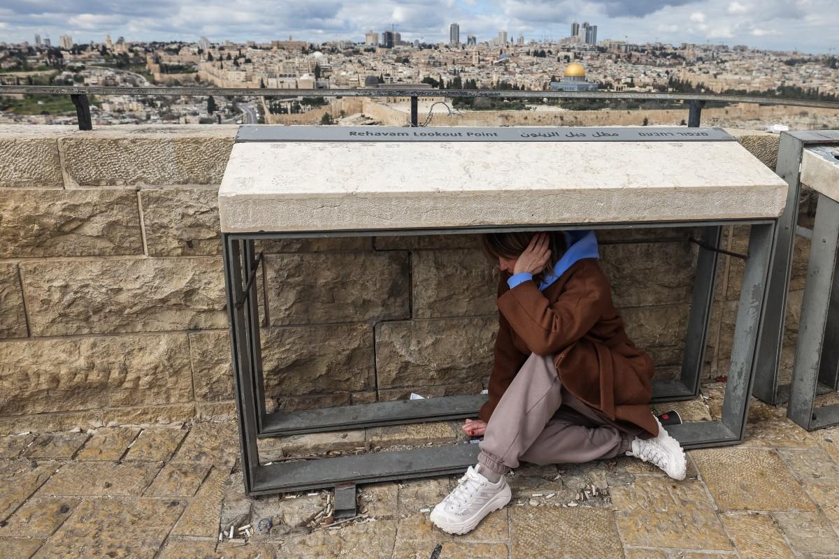 A man takes shelter as sirens sound in Jerusalem. Photo: AFP