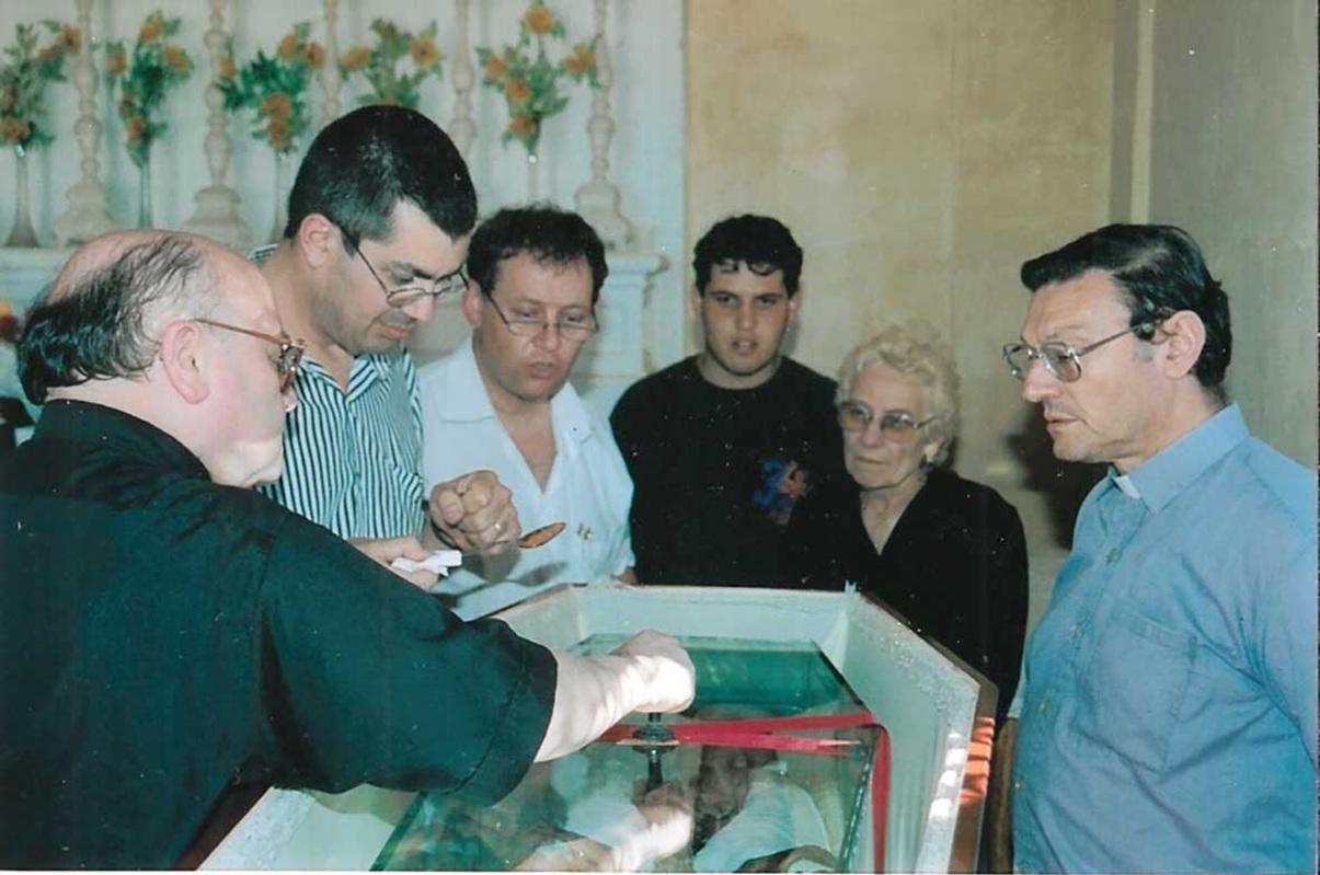 Mgr Giovanni Bosco Gauci, Vicar General of the Gozo diocese, certifying the exhumation 25 years ago, while Dr Anthony Abela Medici (third from left) and St Lawrence parish priest Can. Michael Borg (right) look on.