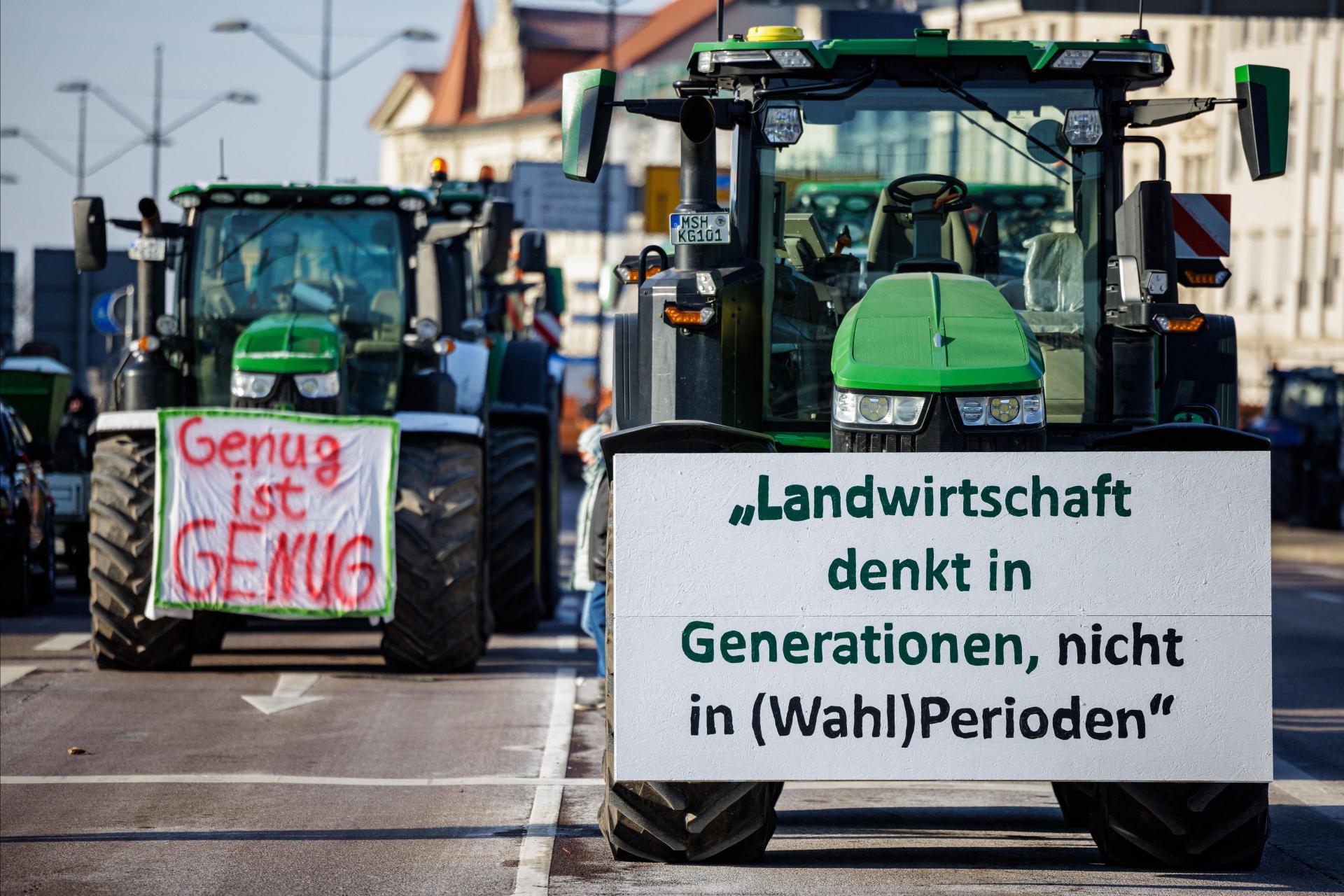 Banners reading "Enough is enough" (L) and "Agriculture thinks in generations, not in (legislative) periods" are fixed on tractors during a protest against the federal government's austerity plans in Halle an der Saale, eastern Germany. Photo: AFP
