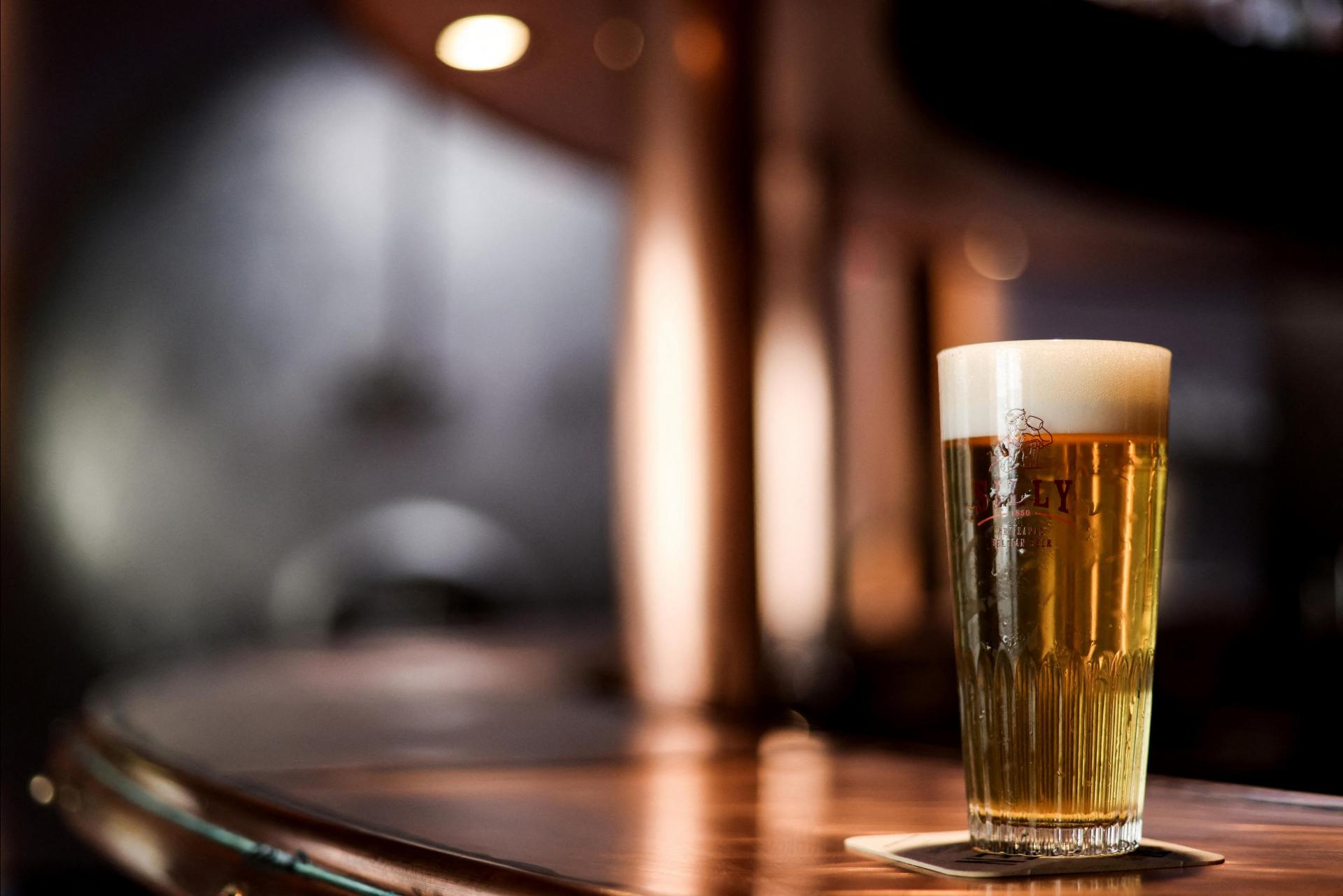 A half pint glass of beer placed on a bar counter.