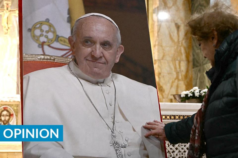 A devotee touches the portrait of the late Pope Francis during a mass in his homage following his death, at the Rome’s Argentinian church Santa Maria Addolorata. Photo: AFP