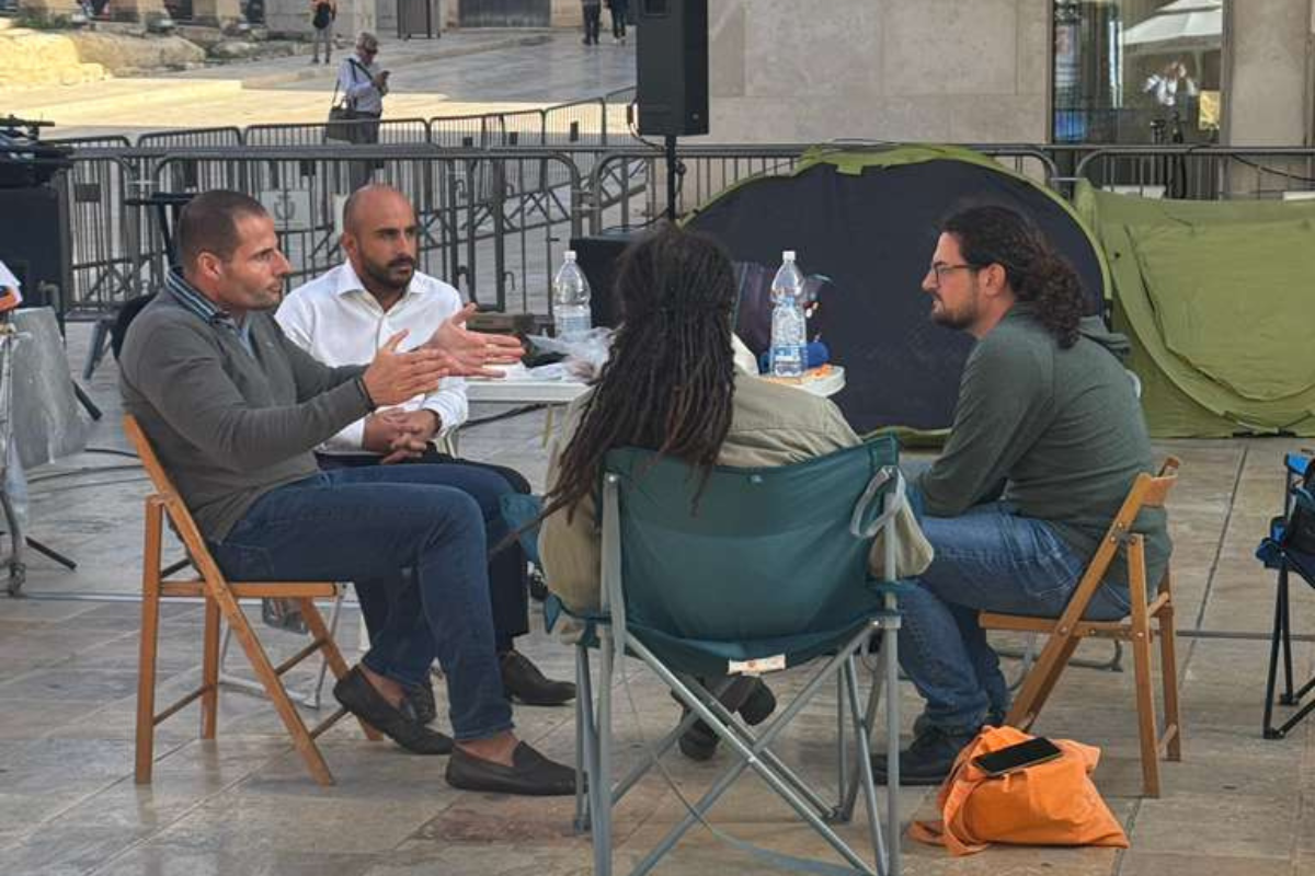 Robert Abela speaks to protesters outside parliament.