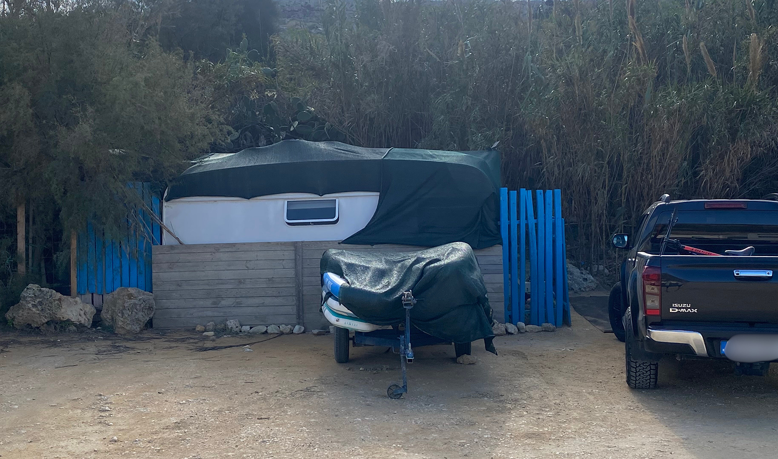 Some motorhomes have a porch and a wooden fence.