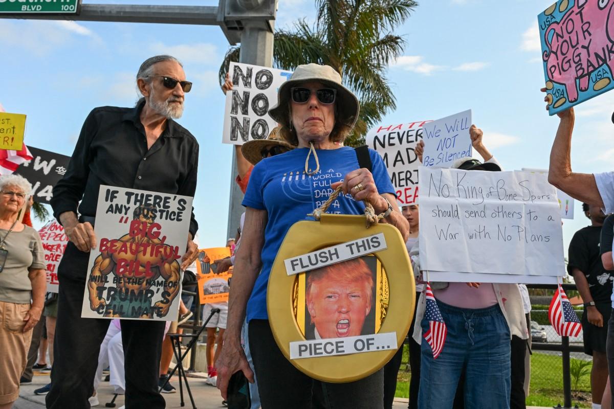 Protesters hold signs near US President Donald Trump's Mar-a-Lago resort. Photo: AFP