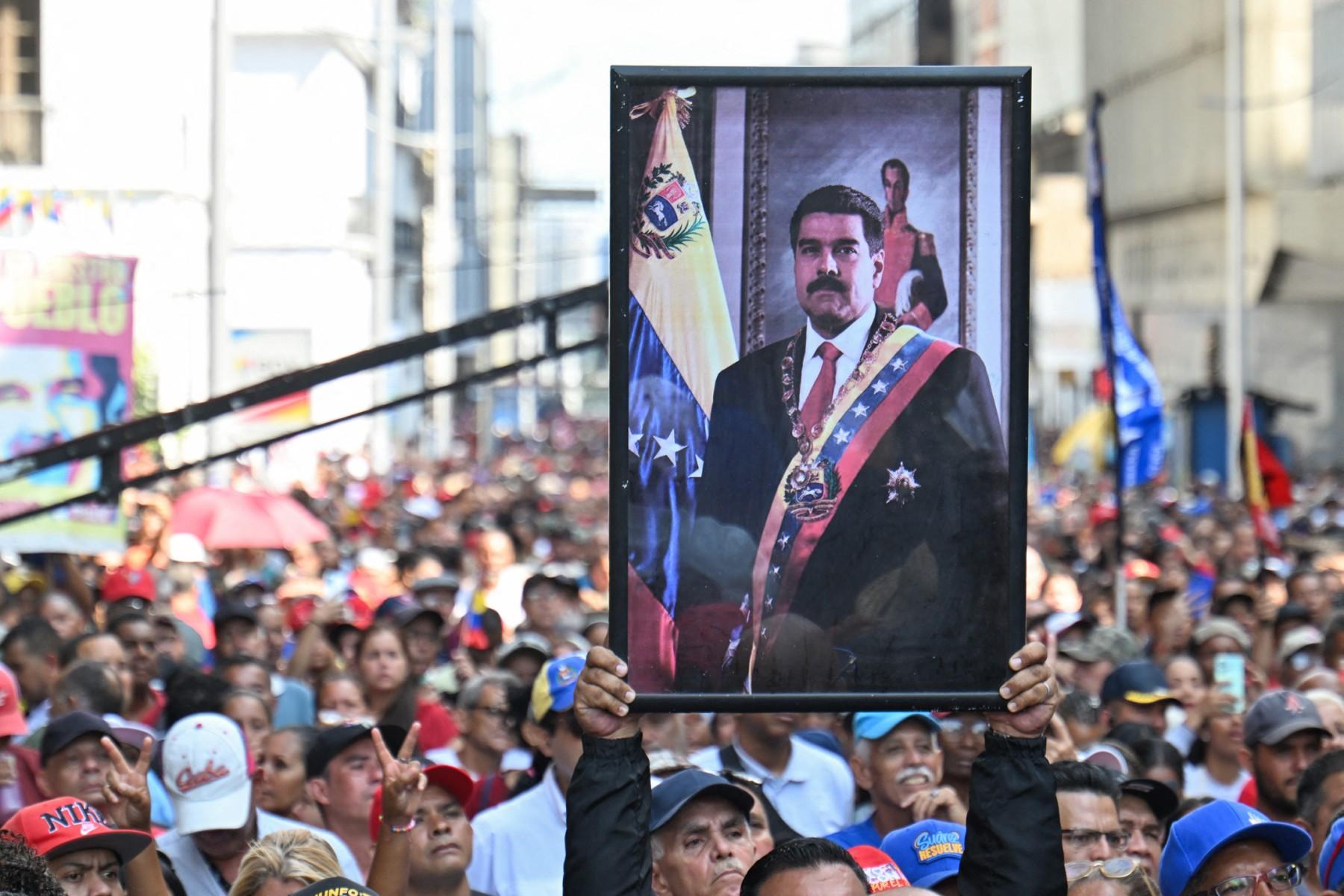 A supporter of ousted Venezuela's President Nicolas Maduro carries his portrait during a rally outside the National Assembly in Caracas.