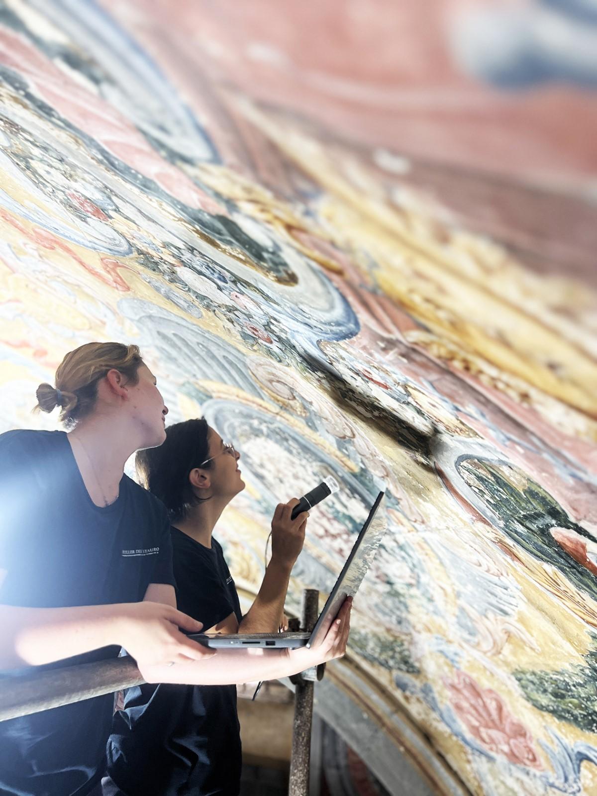 Conservators Annachiara Sottili and Darya Khloptseva carrying out surface investigations of the pictorial layer using a portable microscope.