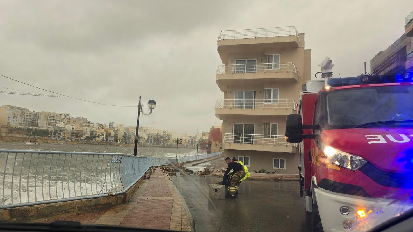 A member of the Civil Protection Department helps remove debris from the road in Marsascala. Photo: Angie Hoover