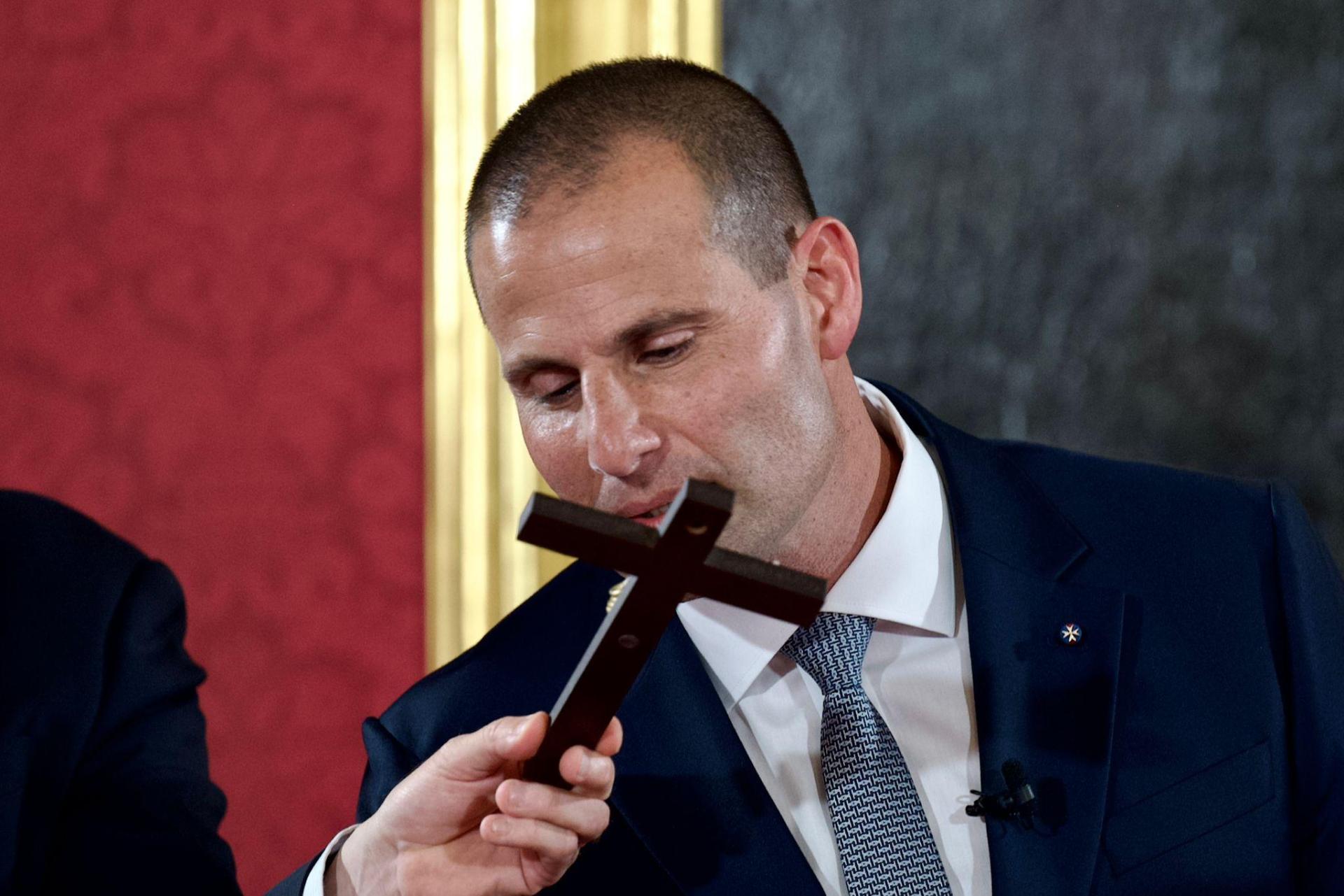 Robert Abela kisses the cross as part of the swearing-in ceremony at the Grand Master's Palace.