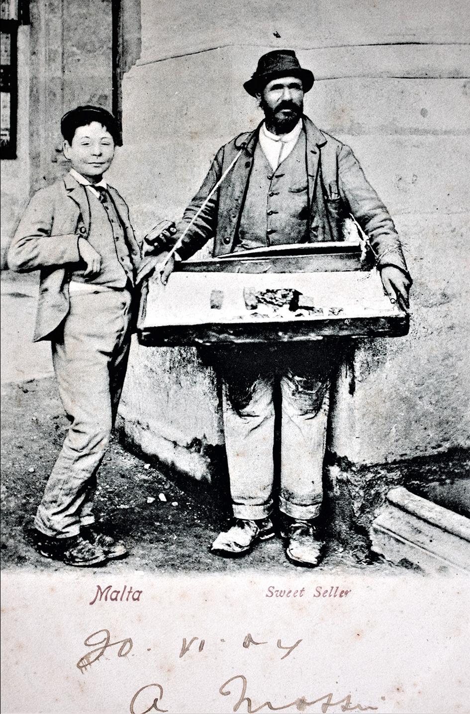 A vendor of confectioneries hawking his wares in this 1904 postcard.