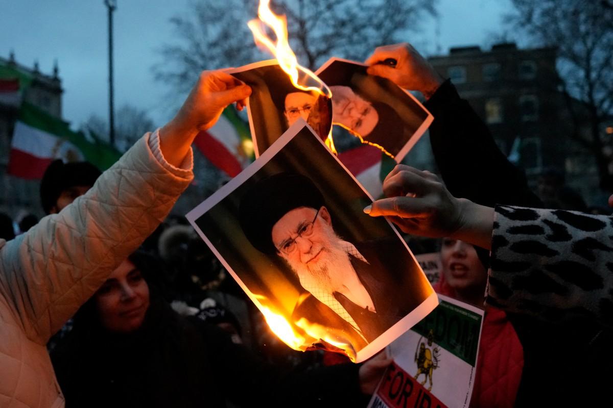 Protestors burn images of Ayatollah Ali Khamenei during a rally held in Solidarity with Iran's Uprising, organised by The national Council of Resistance of Iran, on Whitehall in central London on Sunday. Photo: AFP