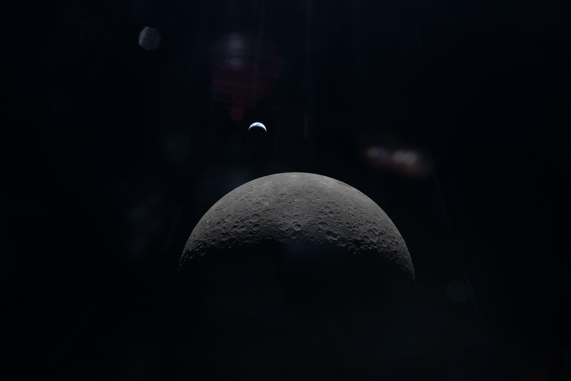 The Artemis II crew captures a faint view of a crescent Earth above the horizon on the Moon&rsquo;s far side. Photo: NASA